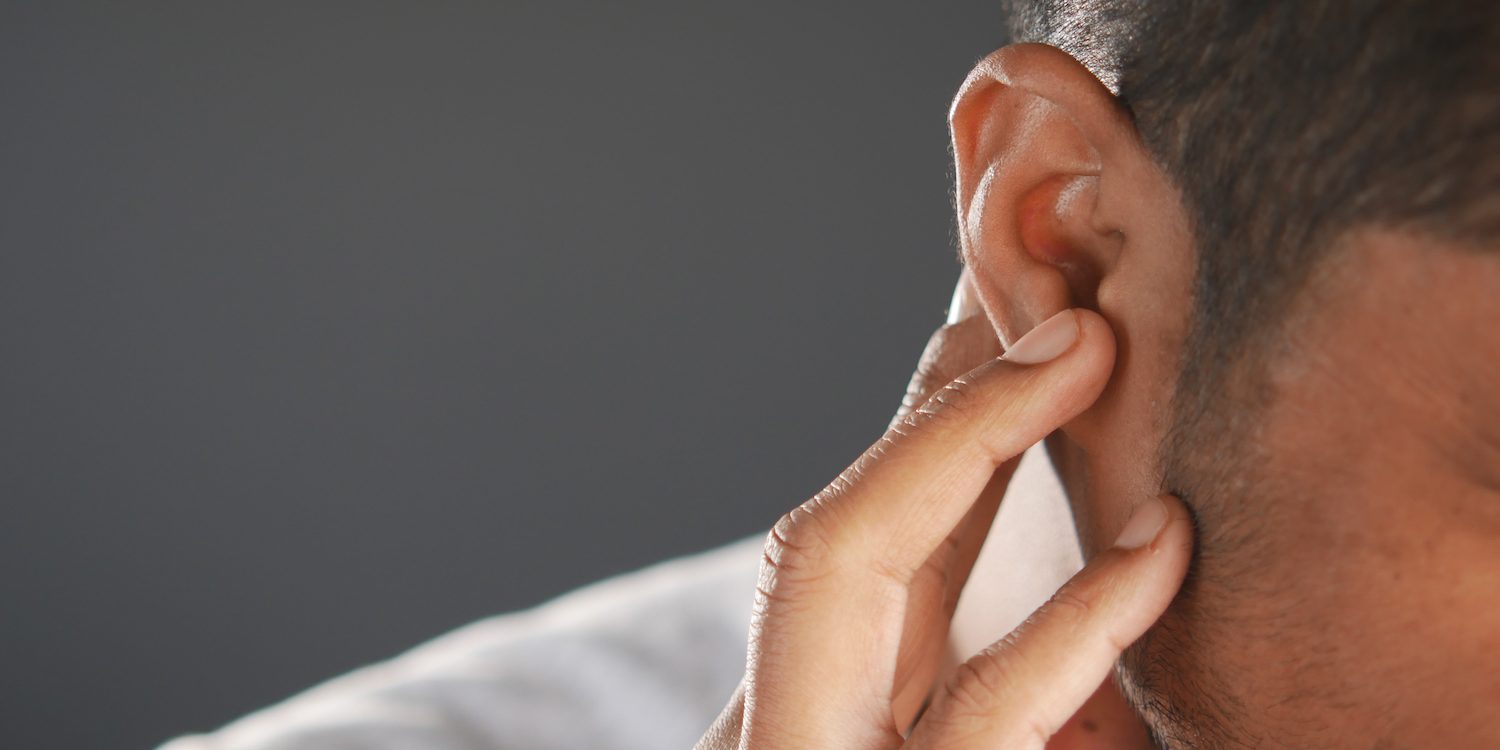 young man having ear pain touching his painful ear , Διάτρηση τυμπάνου